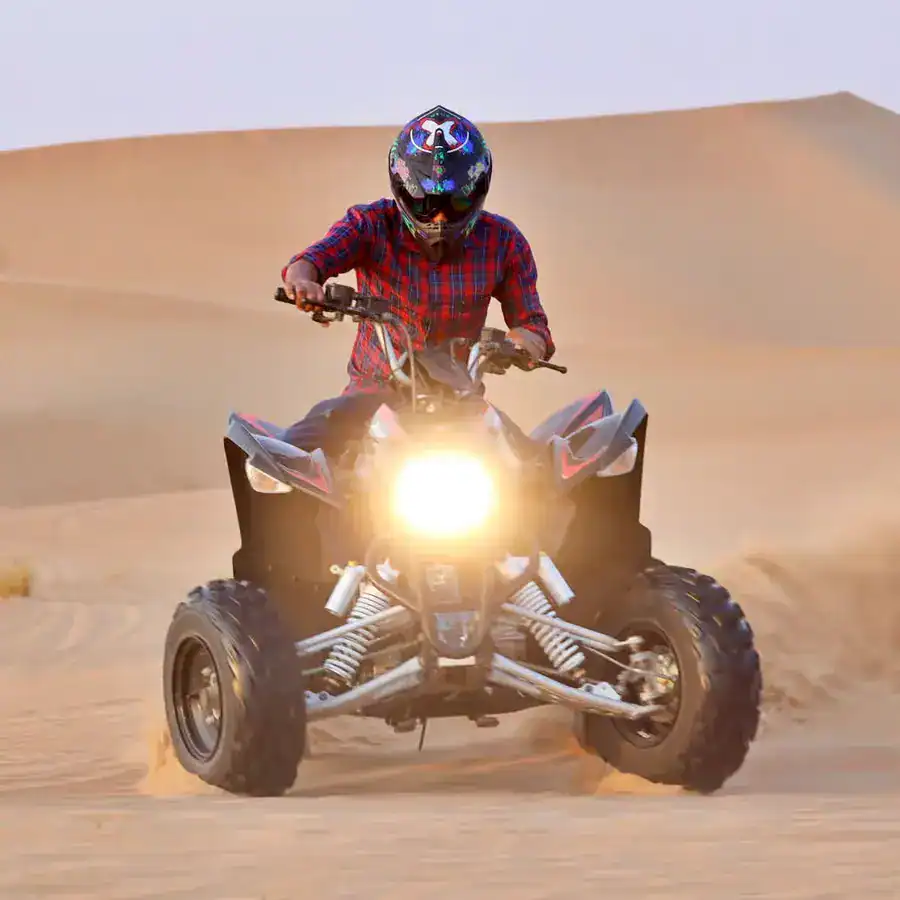 Quad Biking Dubai Price 2026 – tourist riding quad bike in Dubai desert at sunset